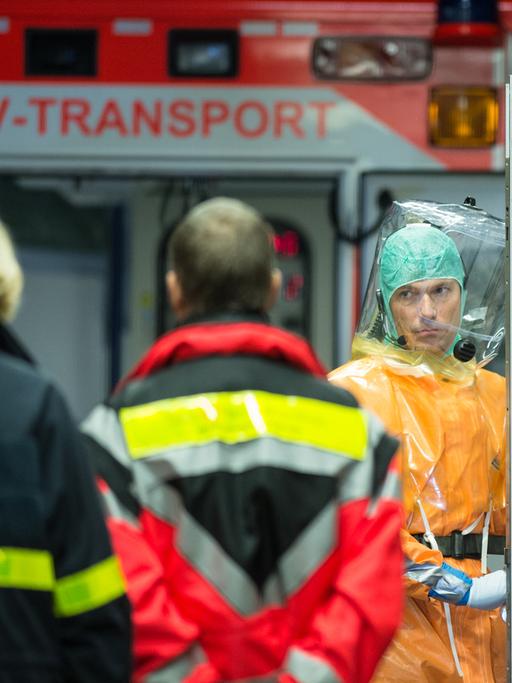 Ein an Ebola erkrankter Patient wird mit einem speziellen Krankenwagen zur Isolierstation der Uniklinik in Frankfurt am Main (Hessen) gebracht. Feuerwehrleute und Ärzte in Schutzanzügen begleiten die Ankunft des Mannes.