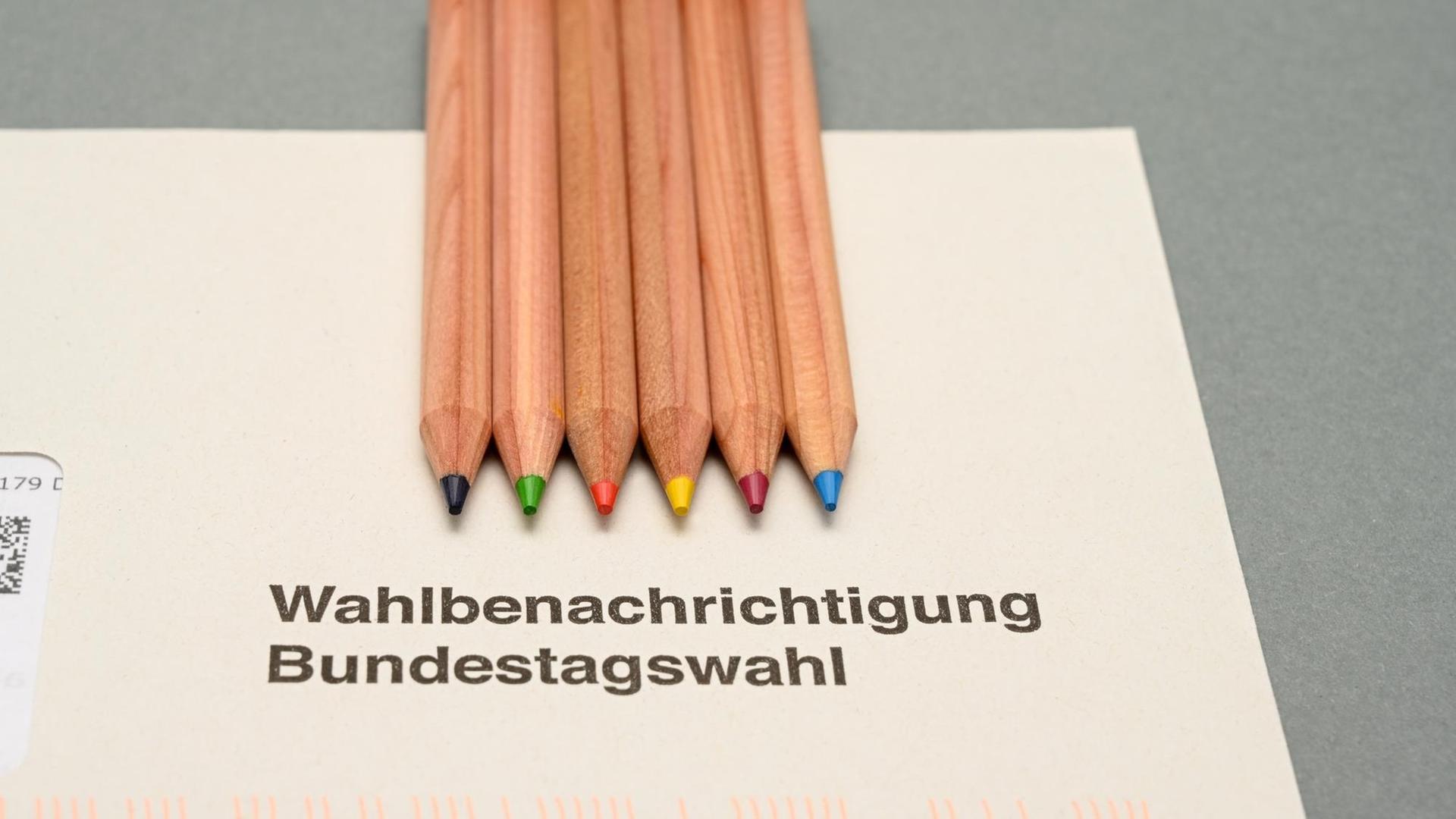 Wahlbenachrichtigung für die Bundestagswahl 2021 mit Stiften in den Farben der politischen Parteien