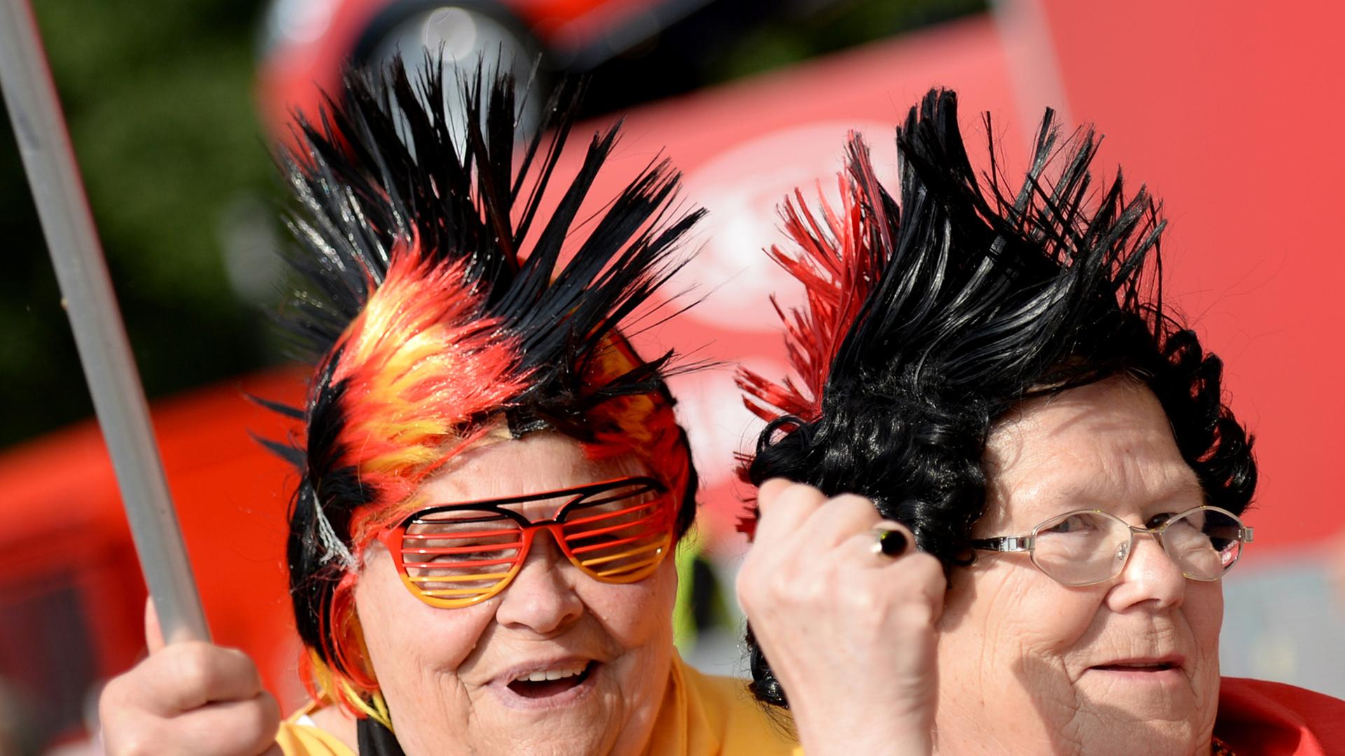 Zwei ältere Fußballfans feiern am 26.06.2014 beim Fan-Fest in Hamburg kurz vor dem WM-Gruppenspiel Deutschland gegen die USA.