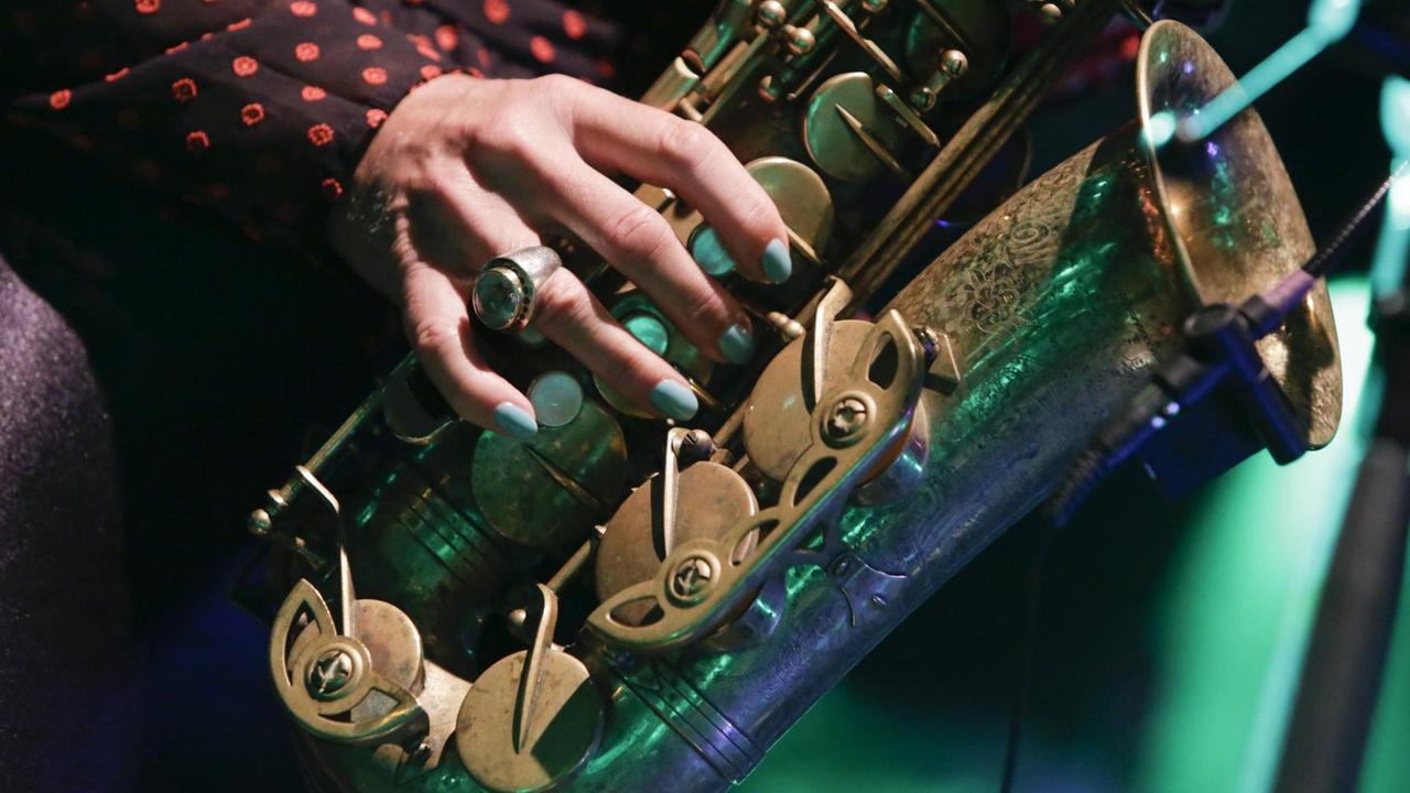 Frauenhände halten ein Saxofon