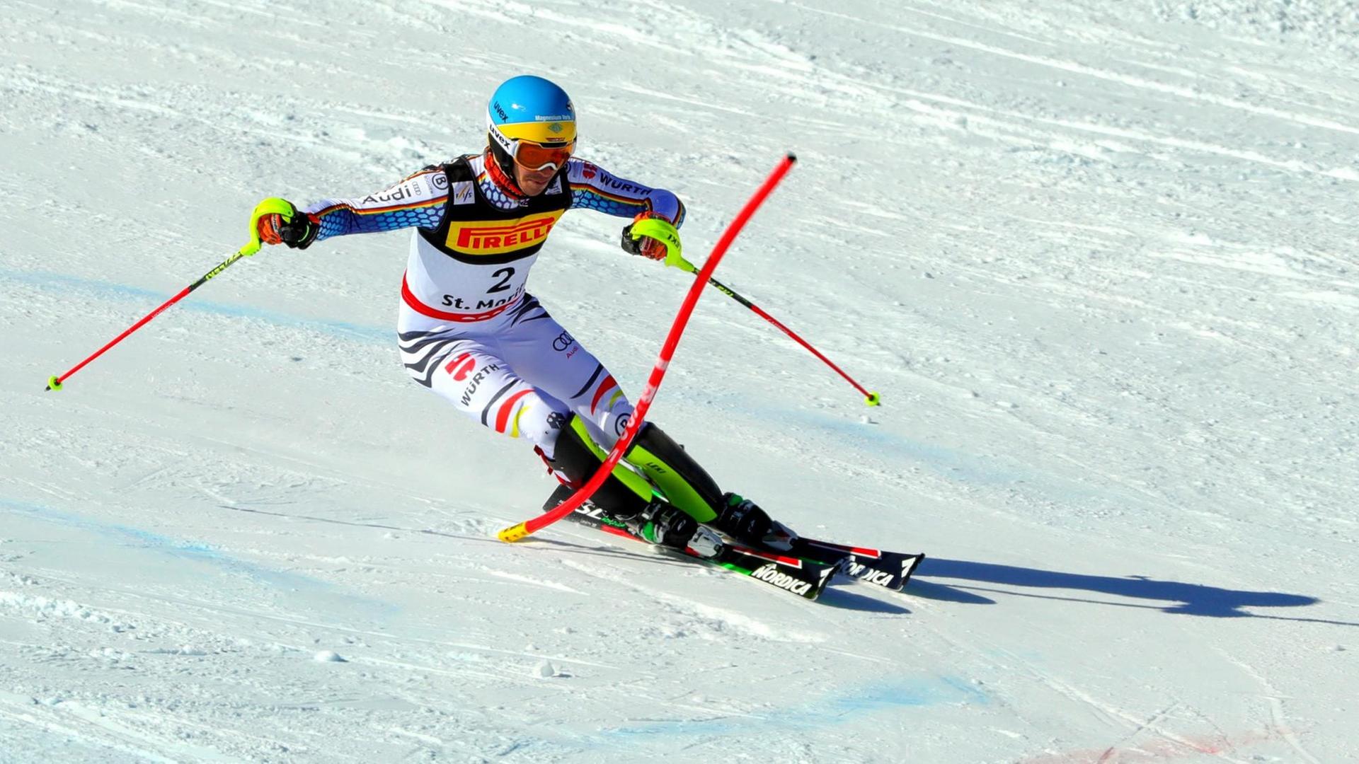 Neureuther fährt beim Slalom in einer engen Kurve um eine Stange herum. 