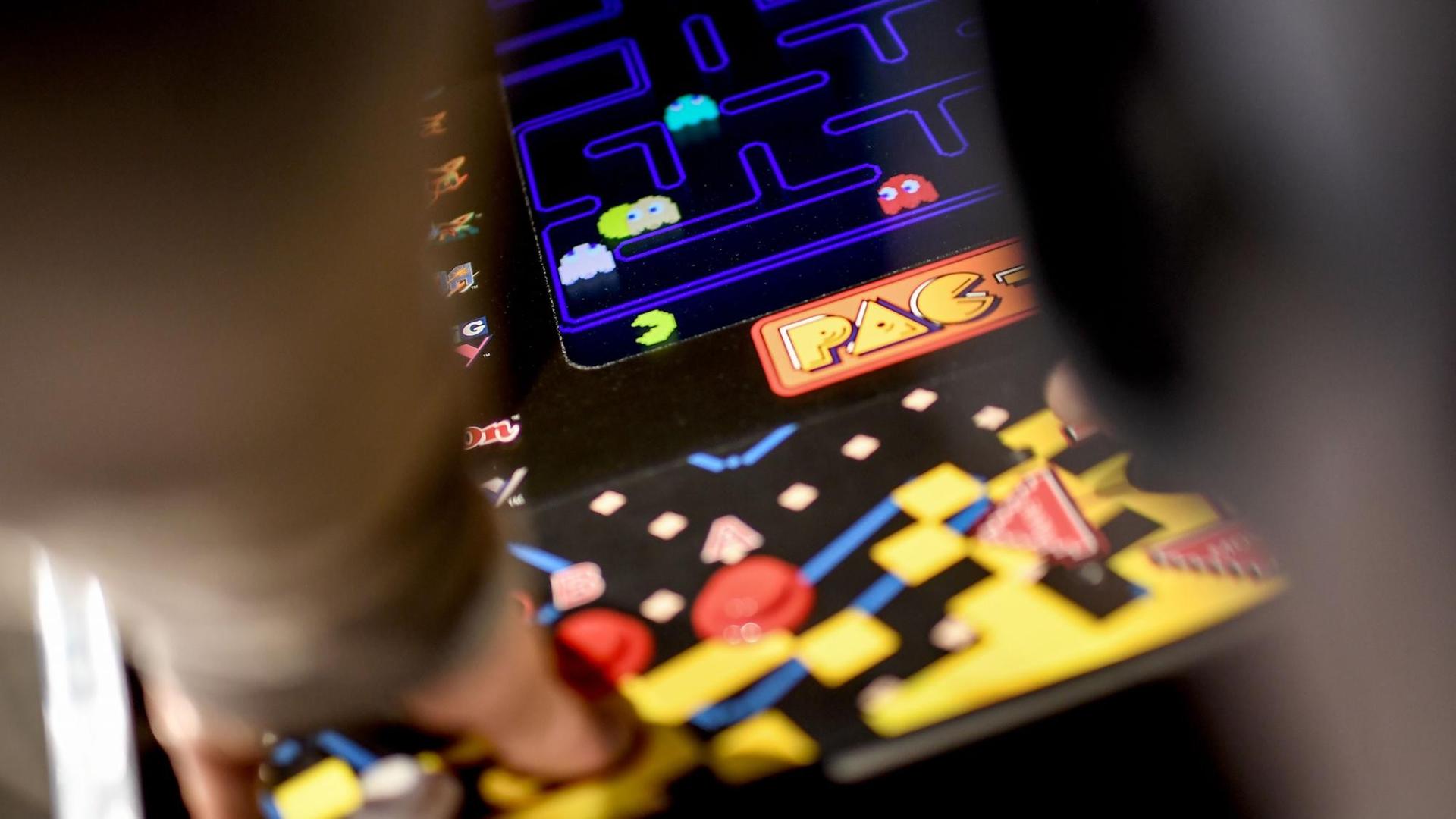 Ein junger Mann spielt das Computerspiel "Pac Man" an einem Automaten in der Ausstellung "Nineties Berlin" in der Alten Münze in Berlin.