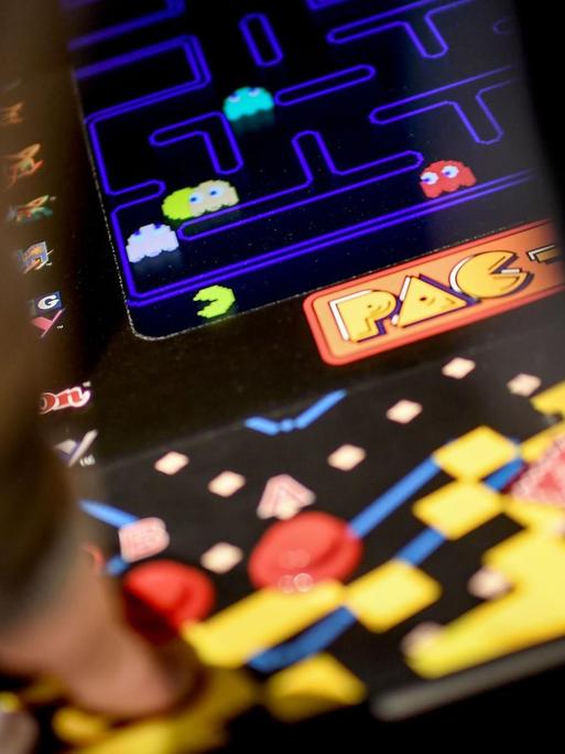 Ein junger Mann spielt das Computerspiel "Pac Man" an einem Automaten in der Ausstellung "Nineties Berlin" in der Alten Münze in Berlin.