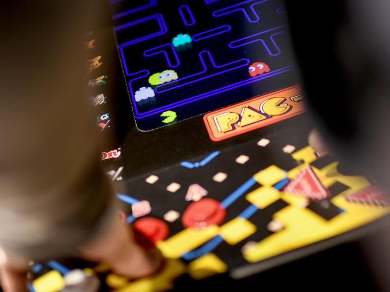 Ein junger Mann spielt das Computerspiel "Pac Man" an einem Automaten in der Ausstellung "Nineties Berlin" in der Alten Münze in Berlin.