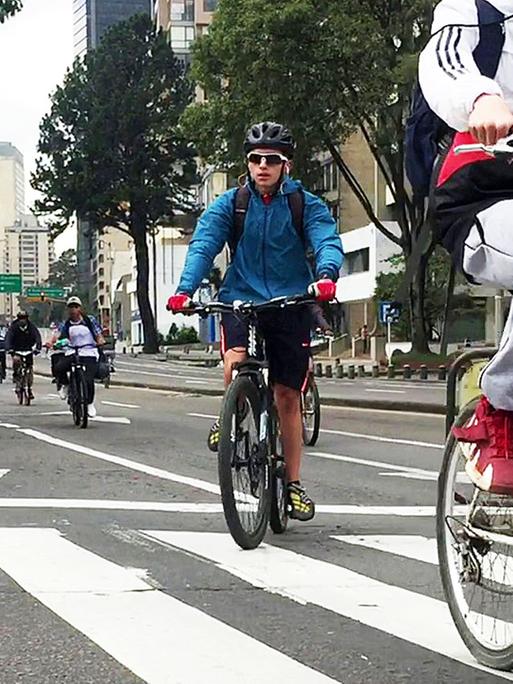 Fahrradfahrer und Fahrerinnen auf einer Fahrradstraße in Bogotá.