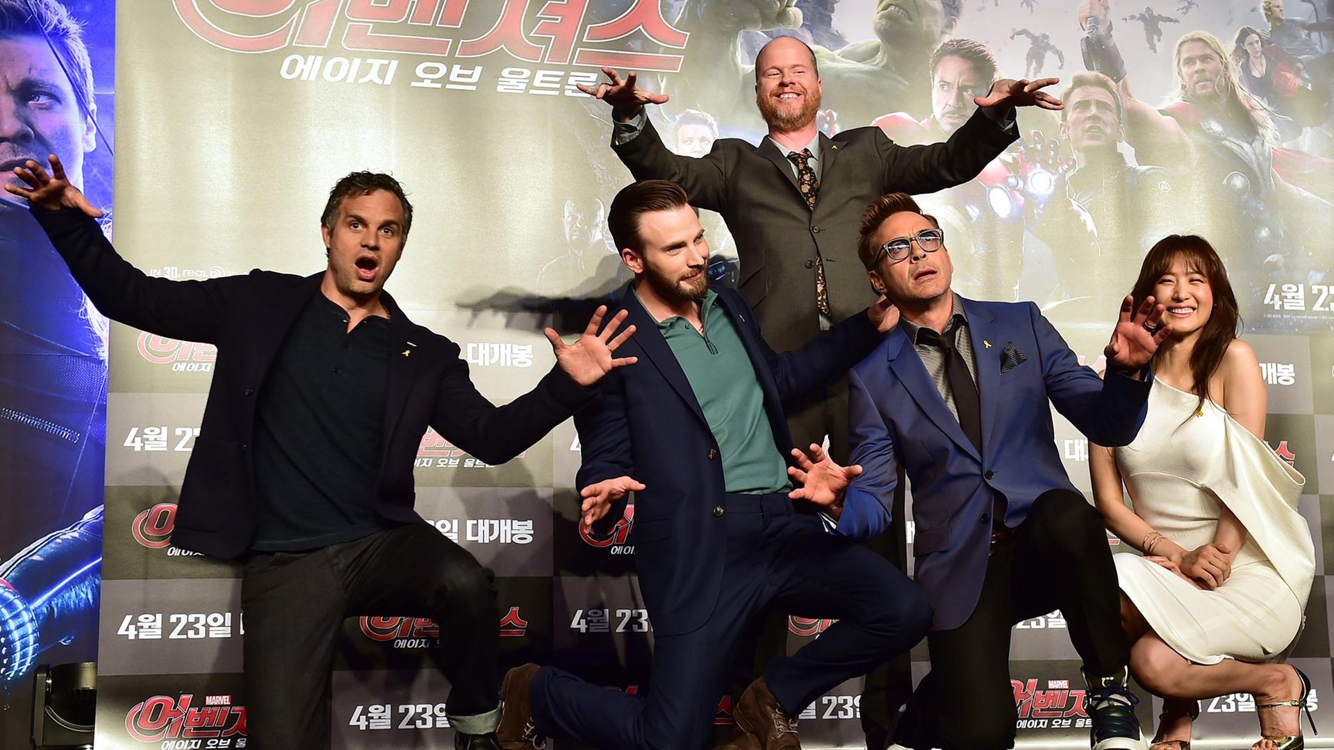 Die Schauspieler Mark Ruffalo, Chris Evans, Robert Downey Jr. und Kim Soo-Hyun sowie Regisseur Joss Whedon posieren vor einem Filmplakat von "Avengers: Age of Ultron"