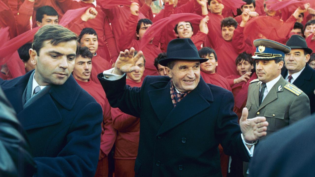 Der rumänische Staats- und Parteichef Nicolae Ceausescu (M) winkt am 24. November 1989 nach dem Parteitag in Bukarest der jubelnden Bevölkerung zu. 
