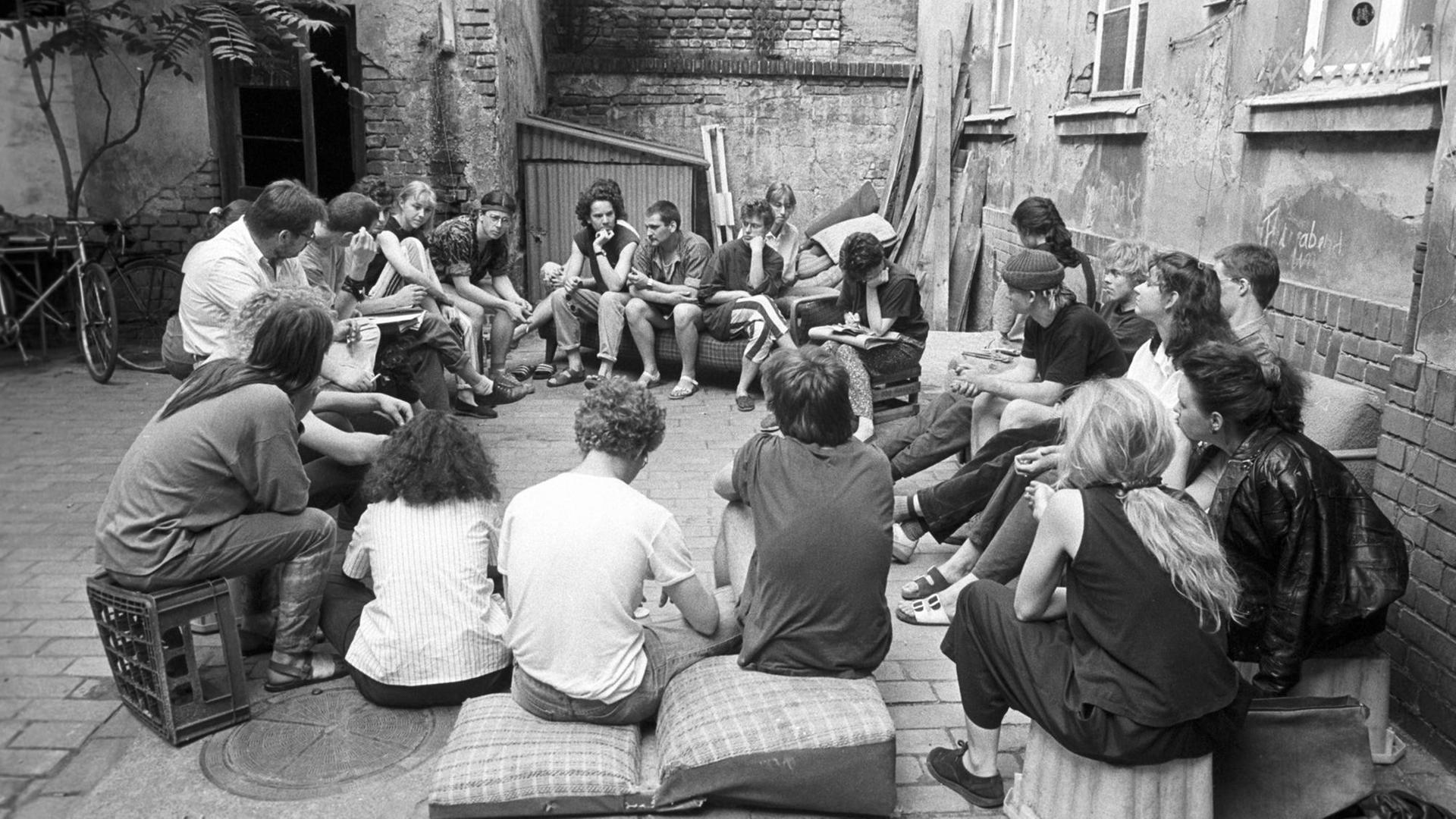 In Leipzig-Connewitz sitzen Jugendliche im Mai 1990 im Hinterhof eines Abrisshauses.