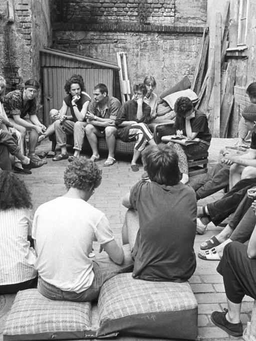In Leipzig-Connewitz sitzen Jugendliche im Mai 1990 im Hinterhof eines Abrisshauses.