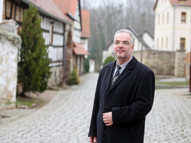 Der zurückgetretene ehrenamtliche Ortsbürgermeister von Tröglitz (Sachsen-Anhalt), Markus Nierth, auf einer Dorfstraße.