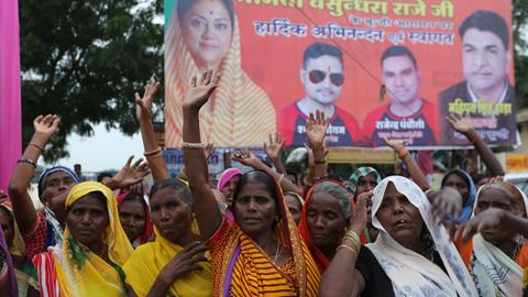 Frauen in indischer Kleidung mit erhobenen Händen demonstrieren für ihre Rechte.