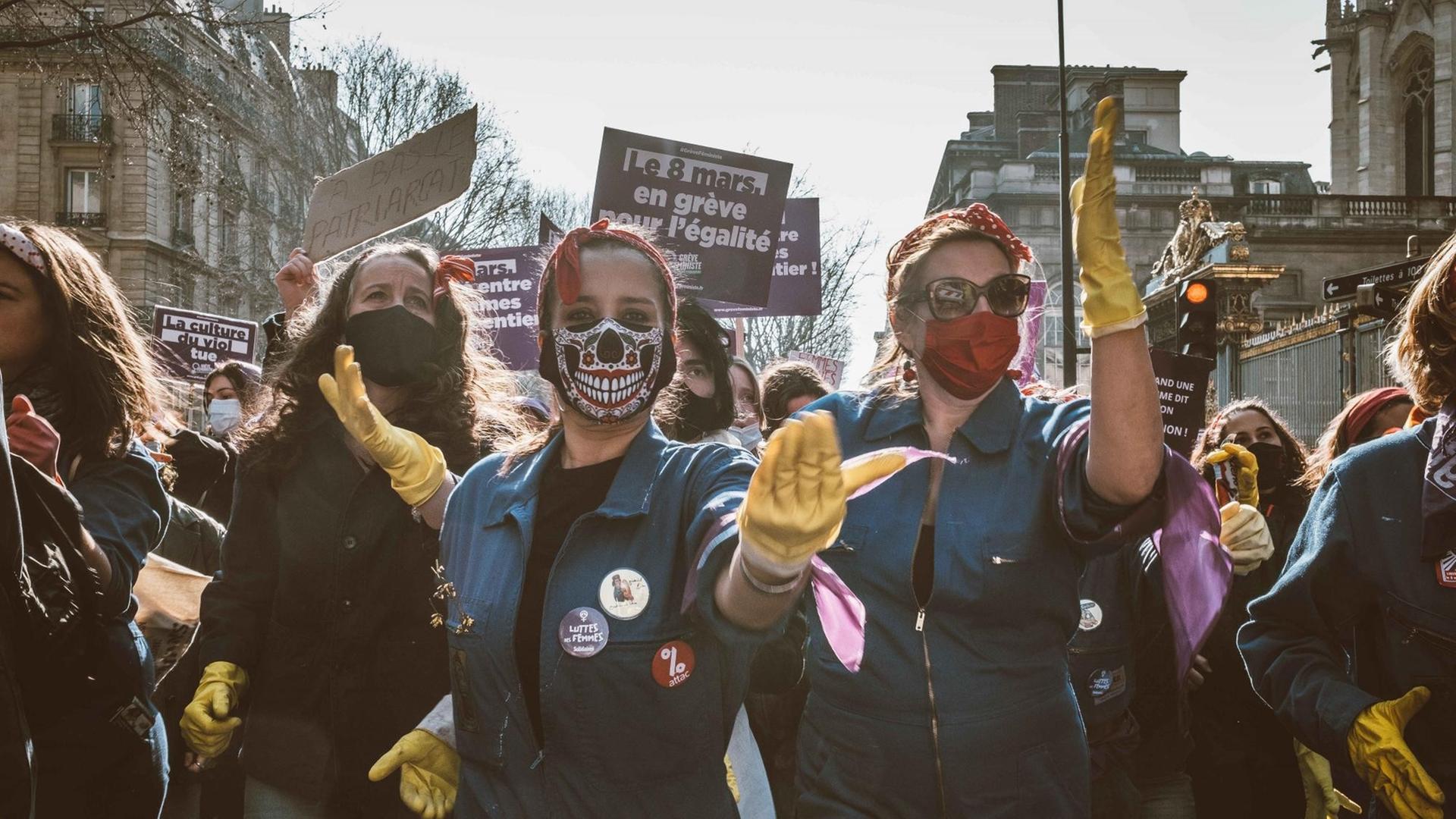 Eine Gruppe junger Frauen mit Mund-Nasenschutz demonstriert auf der Straße für Gleichstellung.