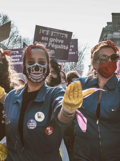 Eine Gruppe junger Frauen mit Mund-Nasenschutz demonstriert auf der Straße für Gleichstellung.