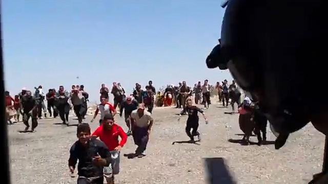Flüchtlinge rennen auf Helikopter-Tür zu.