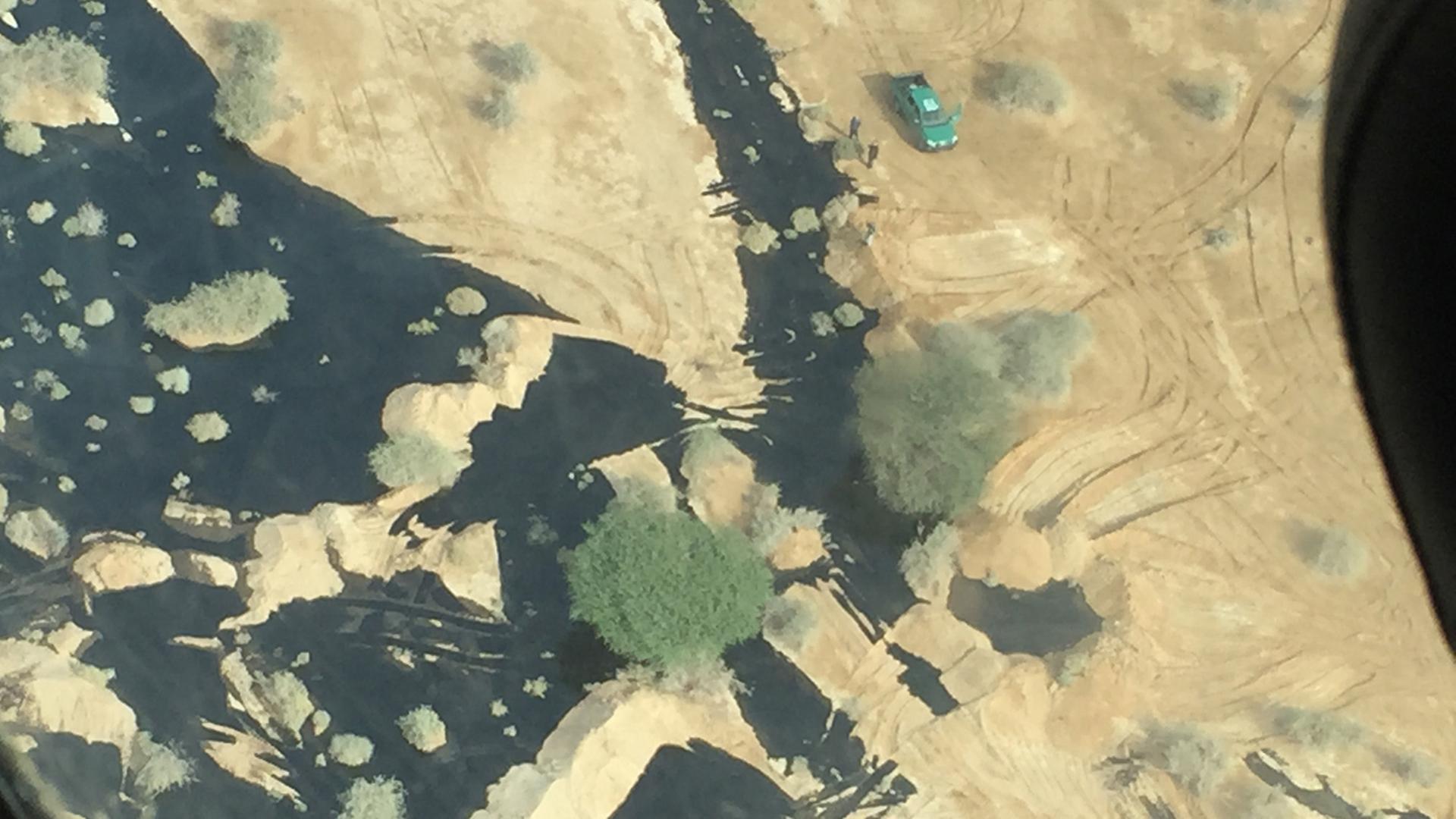 Die Luftaufnahme des israelischen Umweltministeriums zeigt einen schwarzen Ölbäche neben einer Straße durch die Wüste.