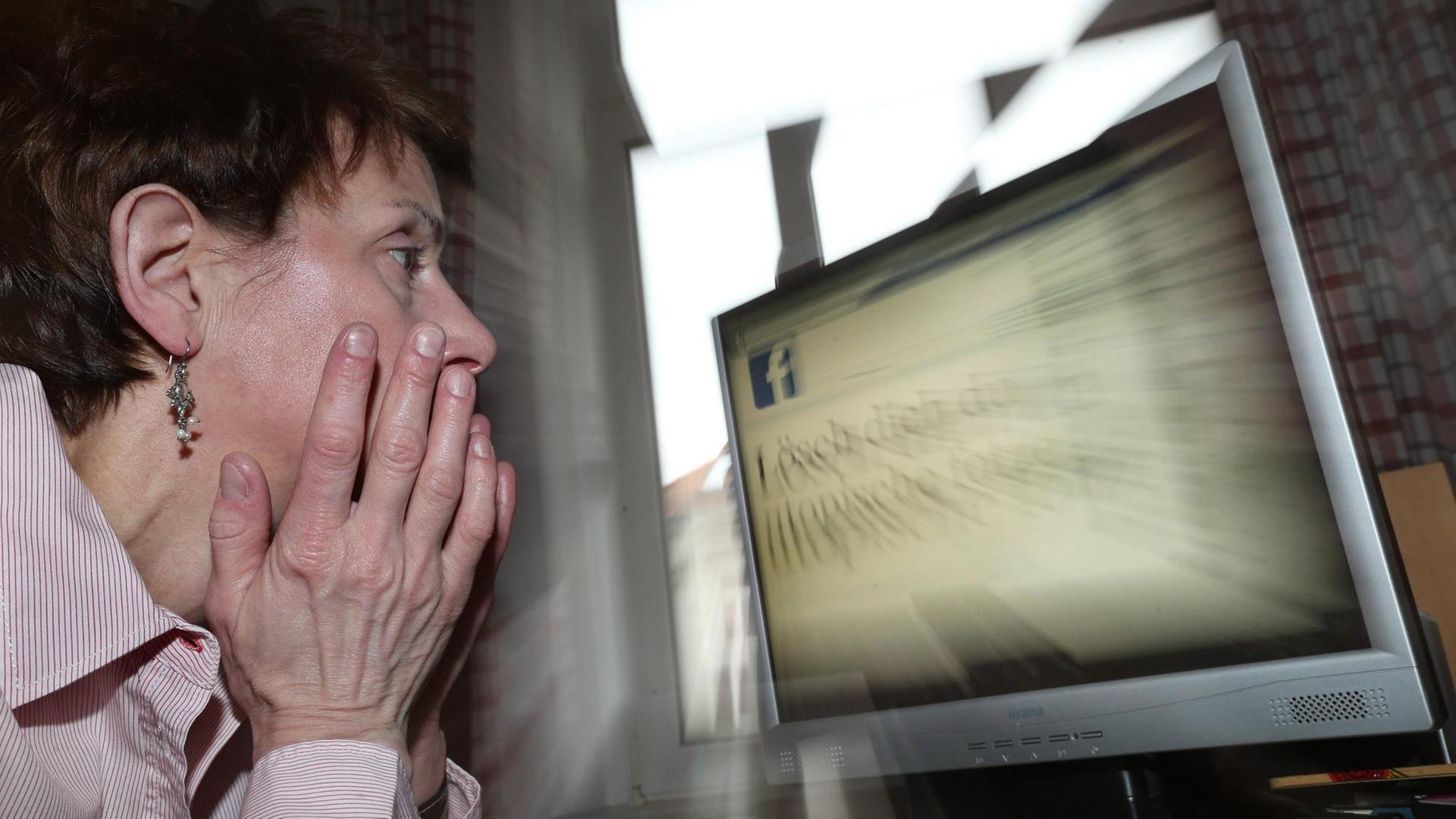 Frau vor einem Bildschirm mit Facebook-Logo