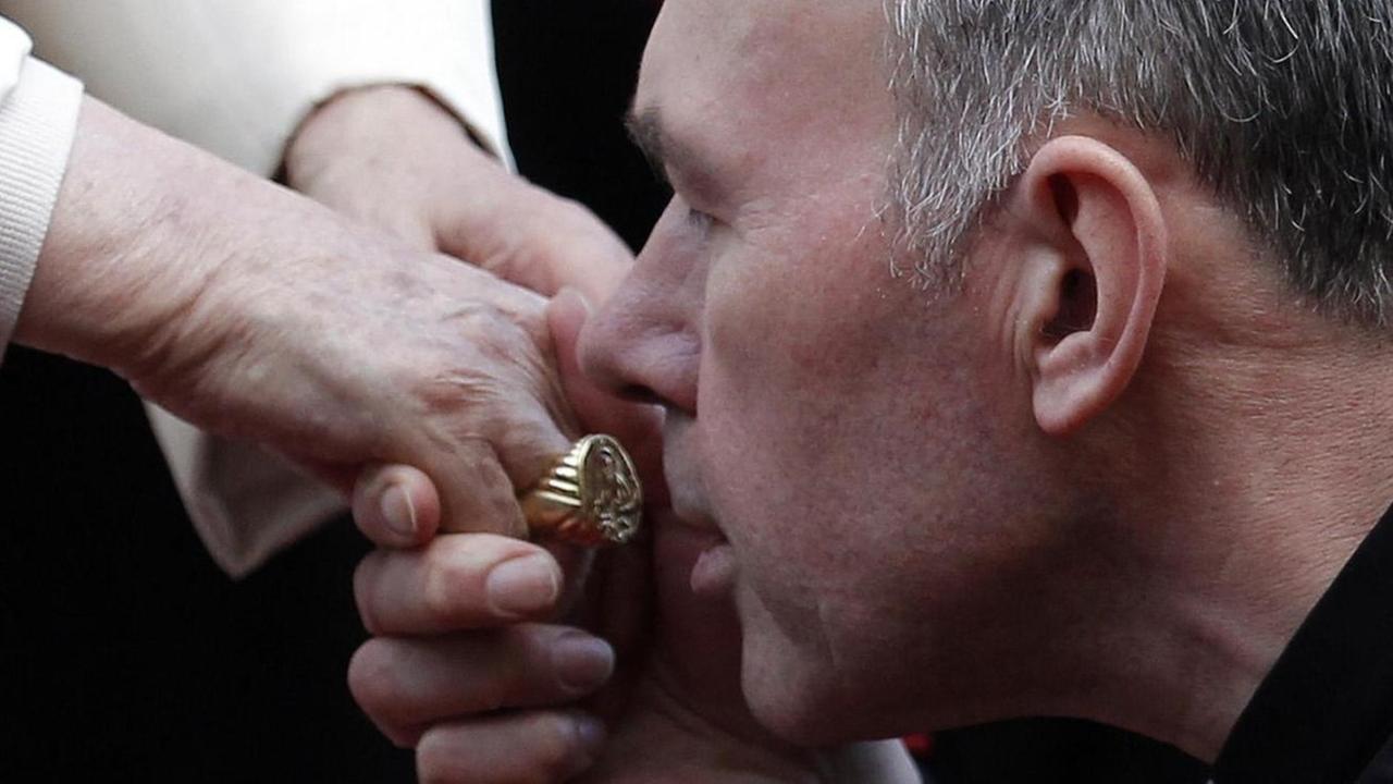 Das Foto zeigt einen britischen Priester, der den Ring von Papst Benedikt XVI. küsst.