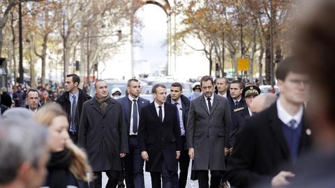 Emmanuel Macron (Mitte) und Innenminister Christophe Castaner (rechts) besichtigen am 2.12.18 den Triumphbogen in Paris nach den Krawallen vom Vortag.