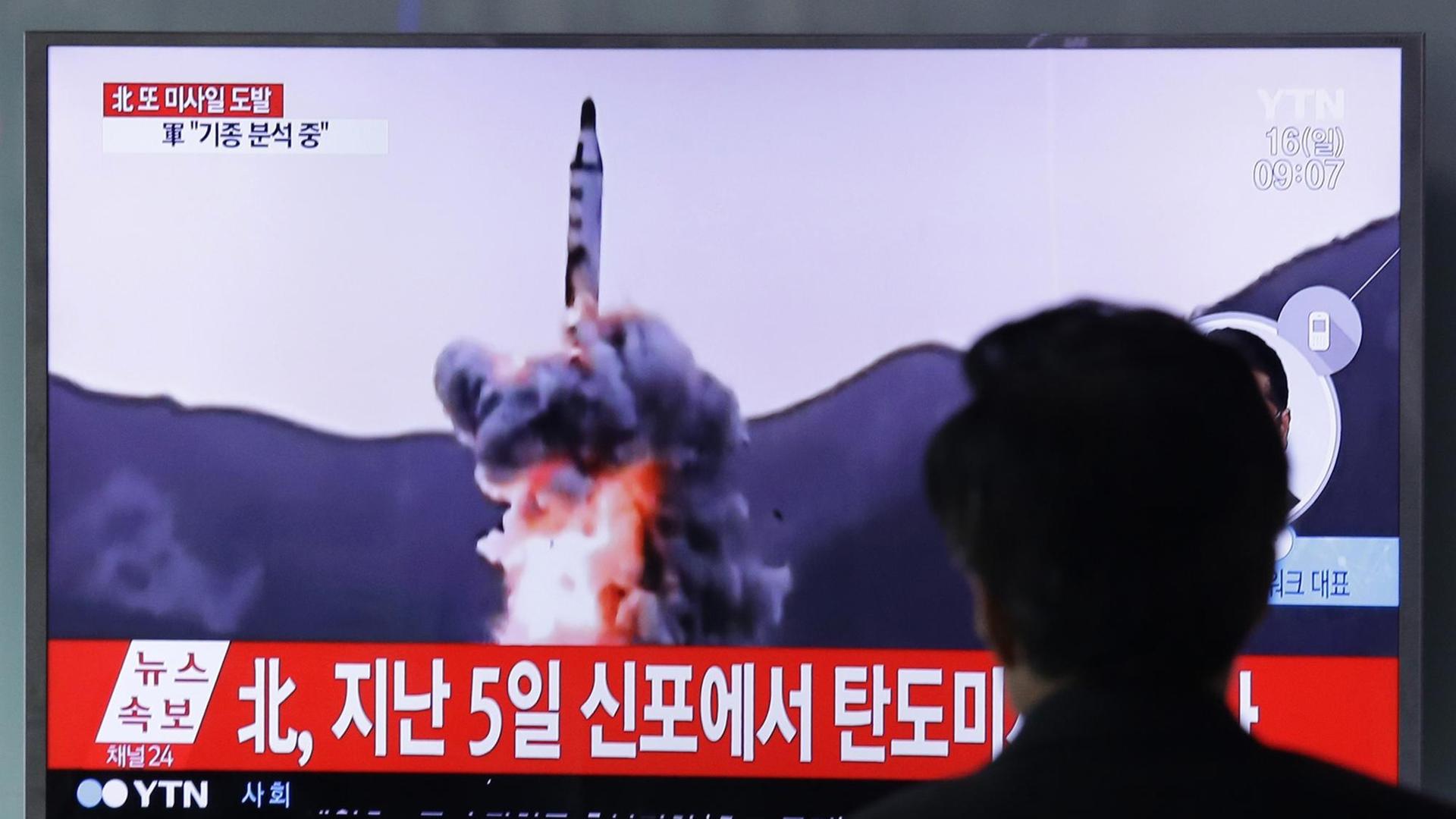 Ein Mann sieht am 16.04.2017 am Bahnhof in Seoul auf einem Fernseh-Gerät eine Archivfilmaufnahme von einer nordkoreanischen Rakete.