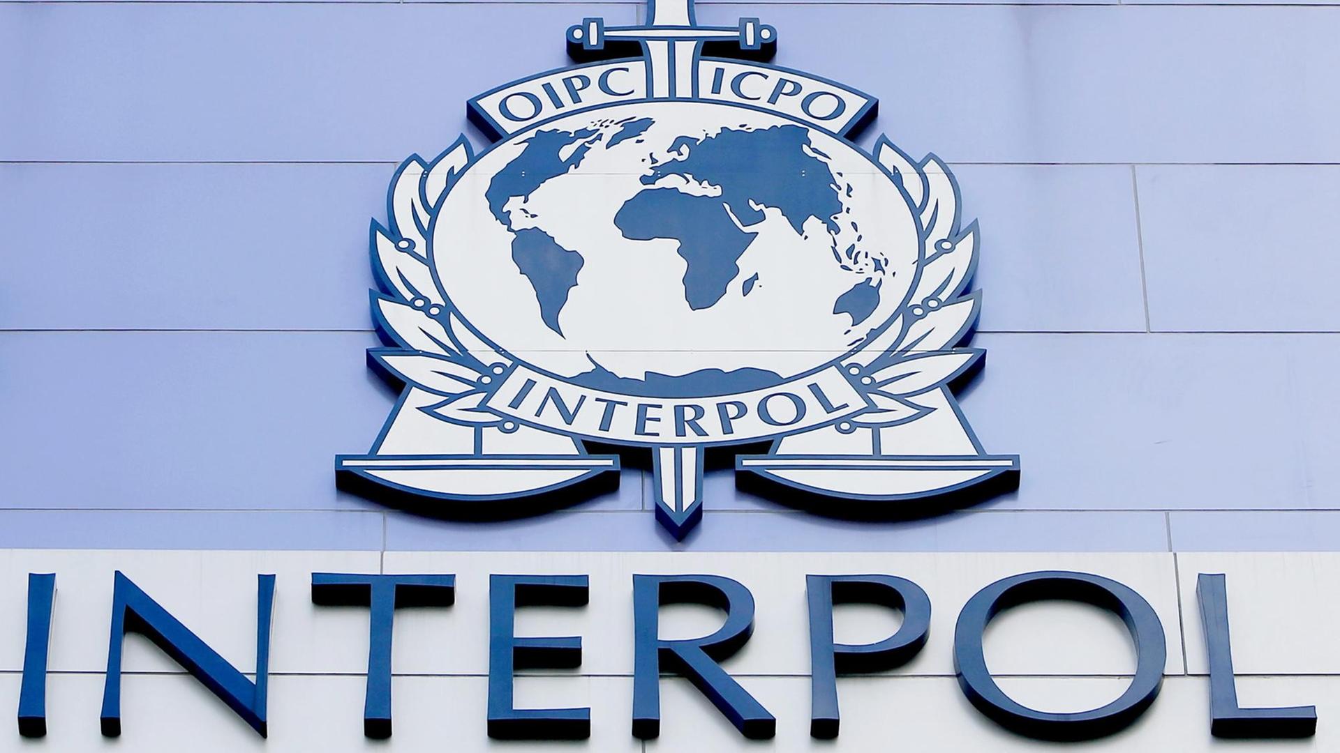 Das Interpol-Logo auf einer Wand Das Interpol-Logo auf einer Wand
