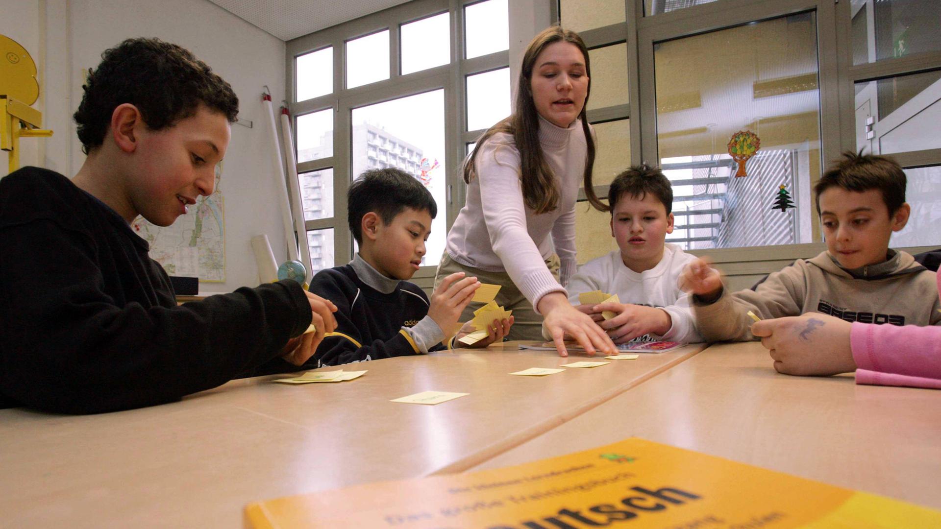 Eine Lehrerin unterrichtet Migrantenkinder in Deutsch.