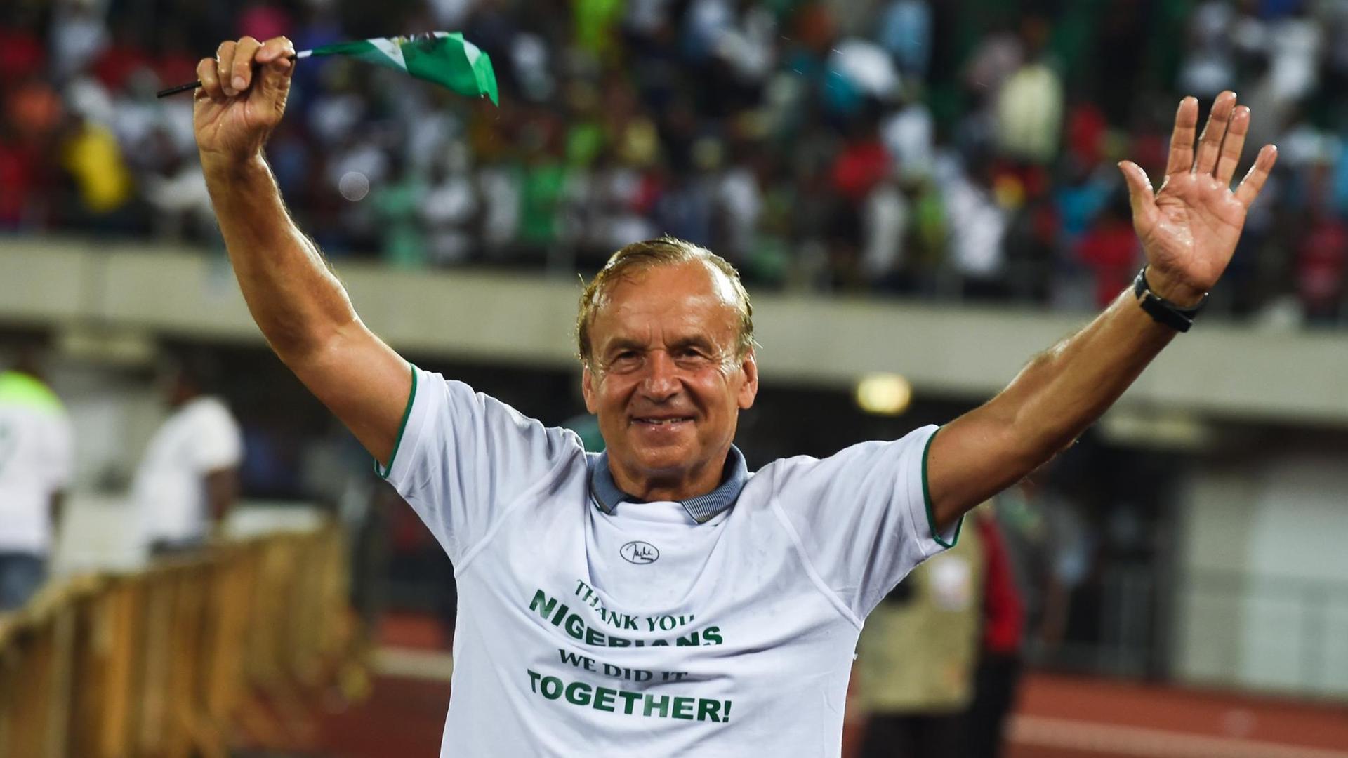 Nigerias Nationaltrainer Gernot Rohr feiert mit einem nigerianischen Fähnchen die Qualifikation für die Fußball-WM.
