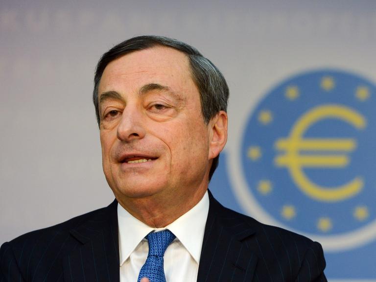 Mario Draghi, Präsident der Europäischen Zentralbank (EZB), im Hintergrund ein Logo mit dem Eurozeichen