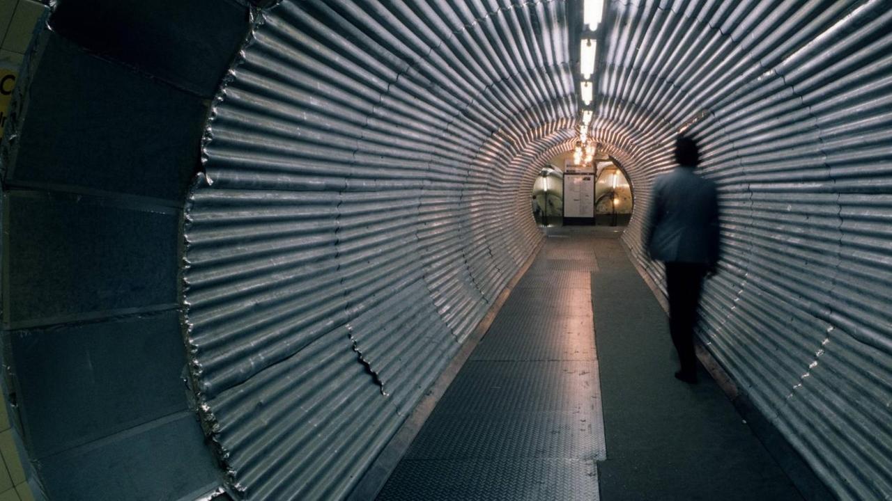Ein Mann geht durch einen Tunnel, der zur Londoner U-Bahn führt.