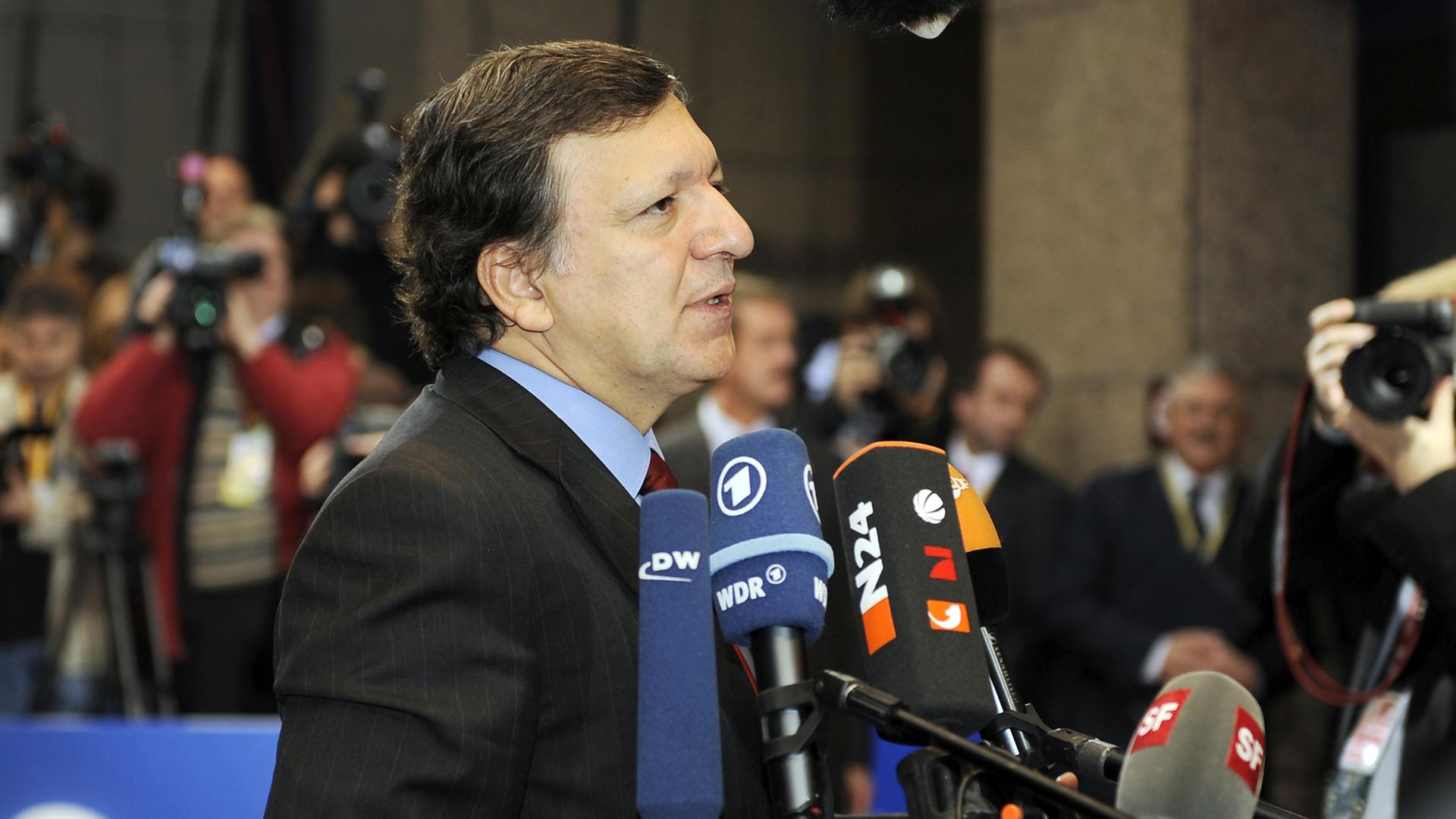 Jose Manuel Barroso, im Profil, steht vor vielen Mikrofonen von Pressevertretern.