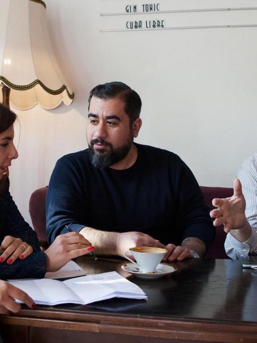 Die syrischen Journalisten Abdul Rahman Mousa, Dima AlBitar Kalaji, Alia Atassi, Rasha AlKhadra und Bassam Dawood sitzen in einem Café in Berlin-Kreuzberg.