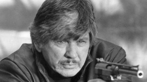 Charles Bronson zielt mit Pistole im Anschlag in einer Szene des Films "Death Wish 3 - Die Rächer von New York" von 1986