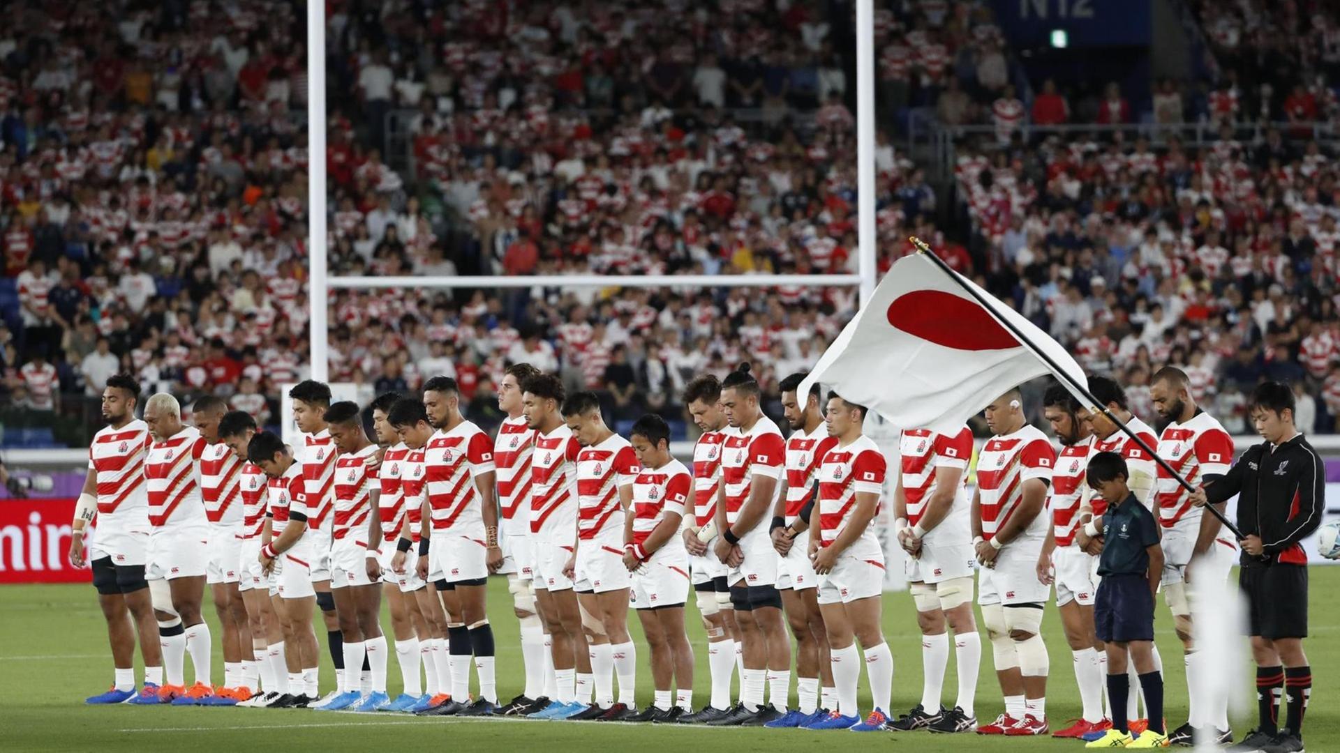 Das japanische Rugby Nationalteam gedenkt vor dem Spiel gegen Schottland in einer Schweigeminute den Opfern des Taifuns