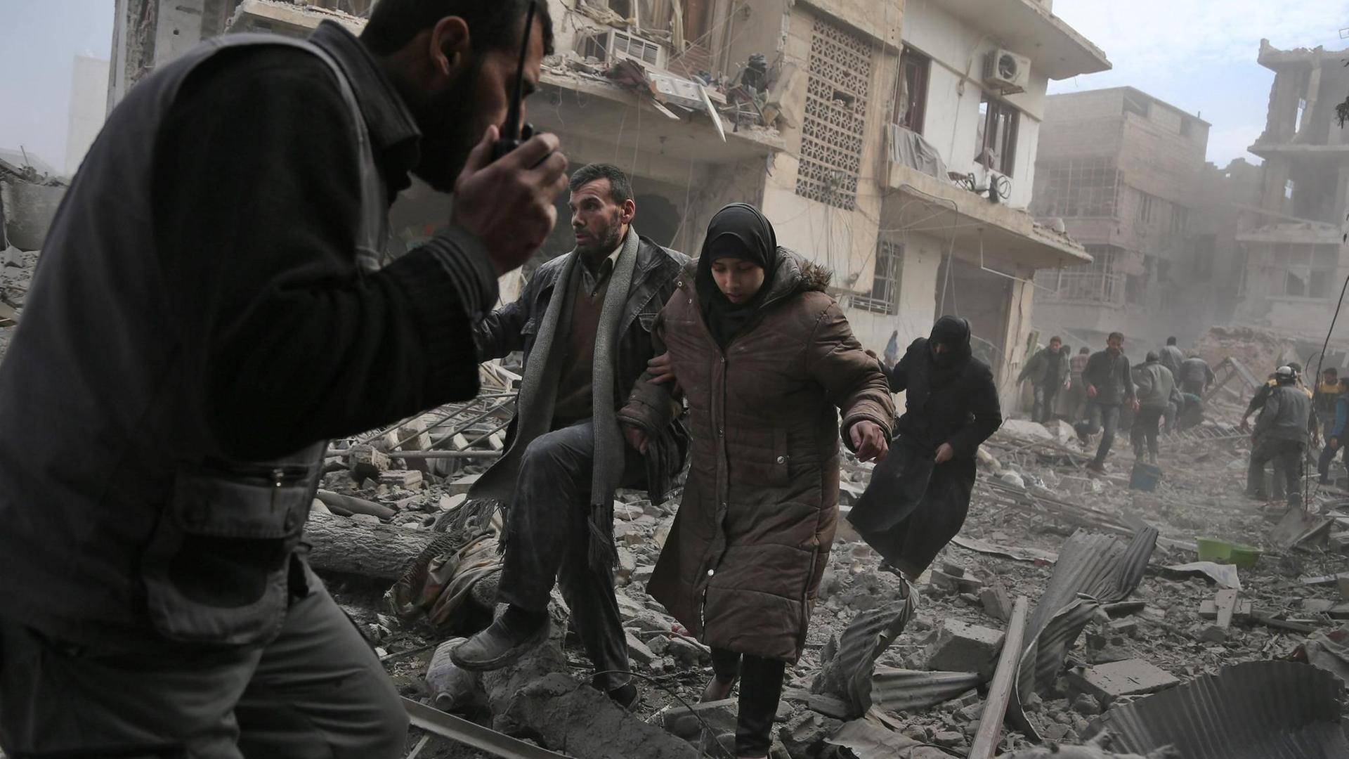 Zivilisten fliehen nach einem Luftangriff auf die Stadt Saqba in der syrischen Rebellen-Enklave Ost-Ghuta.