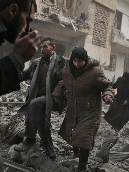 Zivilisten fliehen nach einem Luftangriff auf die Stadt Saqba in der syrischen Rebellen-Enklave Ost-Ghuta.