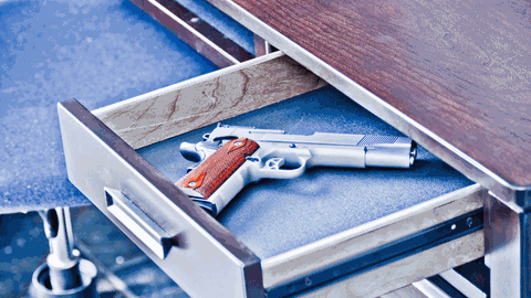 Gefährliche Neueinstellung: Als Reinigungskraft hat Iris Zugang zu fast allen Schubladen im Rathaus. Eine geöffnete Schublade mit einer Pistole darin.