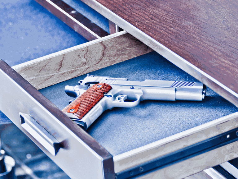 Gefährliche Neueinstellung: Als Reinigungskraft hat Iris Zugang zu fast allen Schubladen im Rathaus. Eine geöffnete Schublade mit einer Pistole darin.