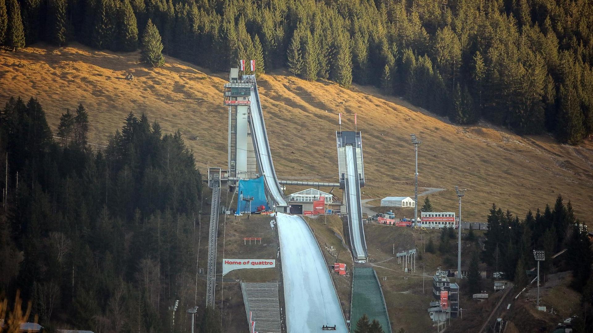 Die Skisprungschanze in Oberstdorf am 27.12.2015 vor schneelosen Bergen.