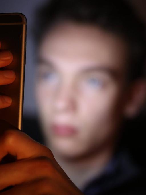 Ein Jugendlicher schaut auf sein Smartphone
