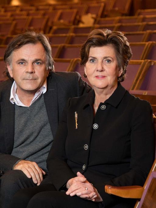 Markus Hinterhäuser und Helga Rabl-Stadler sitzen im Zuschauerraum eines leeren Theaters.
