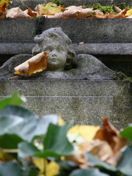 Ein steinernes Engelchen ziert am 14.10.2008 einen Grabstein auf dem alten Südfriedhof in München