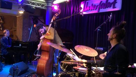 Die Musiker Petros Klampanis, Kristjan Randalu, Bodek Janke auf der Bühne des Münchener Jazzclub "Unterfahrt"