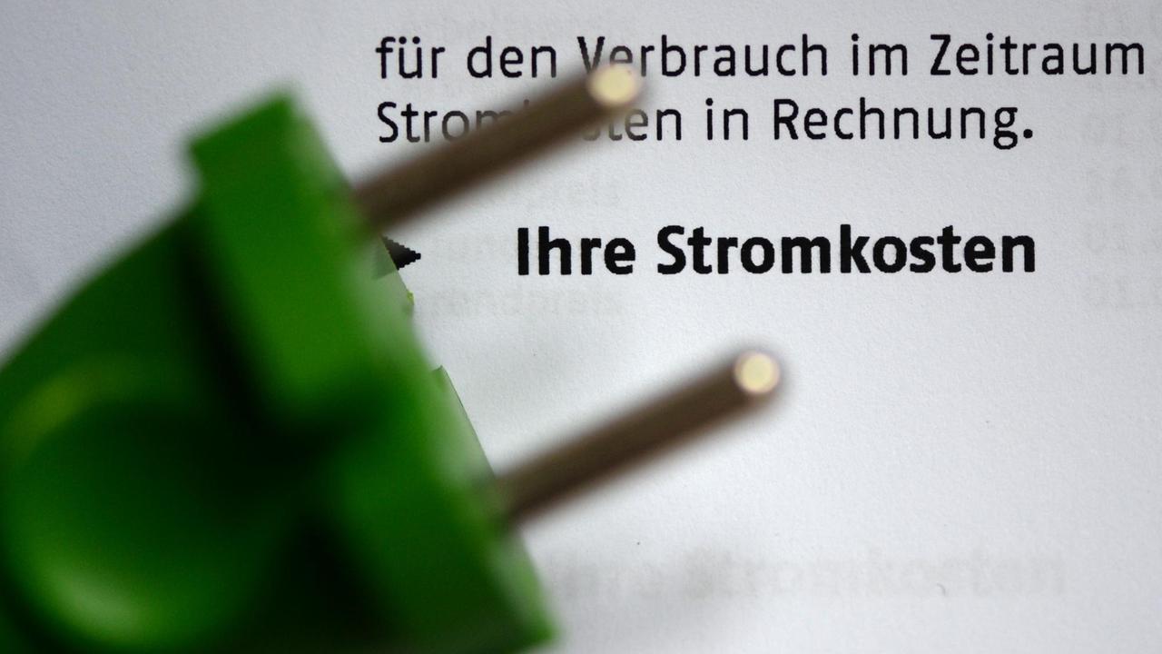 Ein grüner Stromstecker liegt am 03.11.2013 in Berlin auf einer Stromrechnung. 