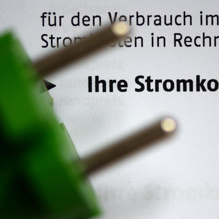 Ein grüner Stromstecker liegt am 03.11.2013 in Berlin auf einer Stromrechnung. 