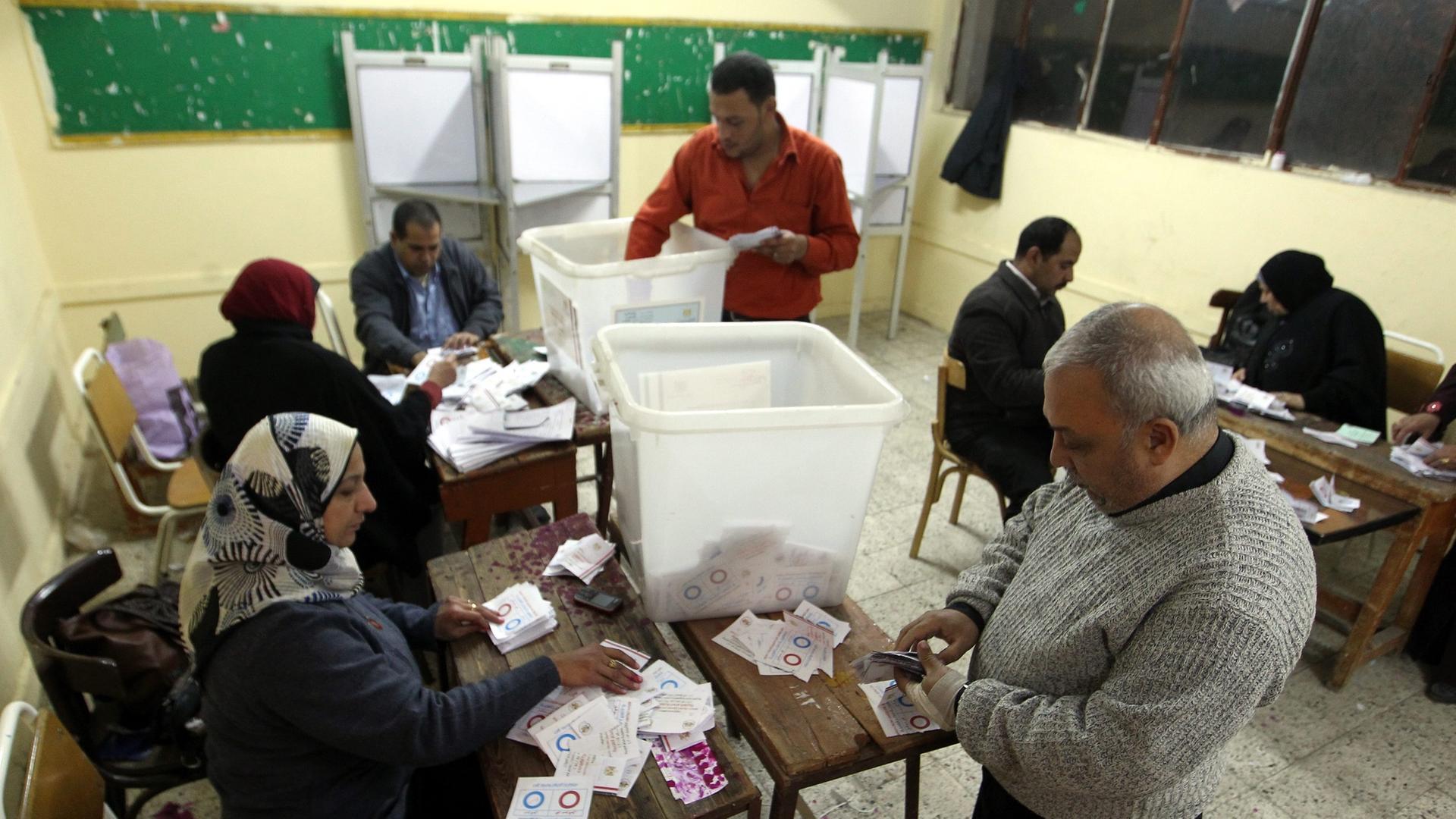 epa04023087 Egyptian election officials count ballots after voting in the second day of a referendum on the new constitution, at a polling station in Helopoils neighborhood in Cairo, Egypt, 15 January 2014. Egypt completed voting in a referendum on a draf