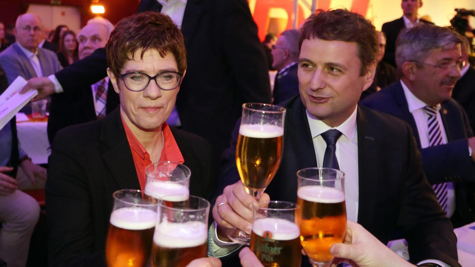 Annegret Kramp-Karrenbauer, CDU-Bundesvorsitzende, und Vincent Kokert, Landesvorsitzender der CDU Mecklenburg-Vorpommern, stoßen beim 24. Politischen Aschermittwoch der CDU Mecklenburg-Vorpommerns mit anderen Teilnehmern mit Bier an.