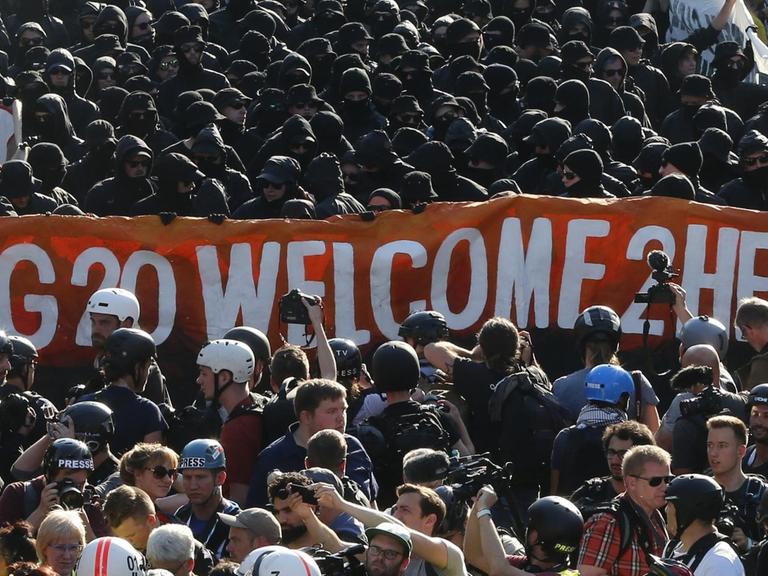 Schwarz gekleidete Demonstranten und Polizisten bei der Kundgebung "Welcome to Hell" in Hamburg.