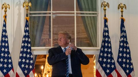 October 5, 2020 - Washington, DC, United States: President Donald J. Trump salutes from the Truman Balcony at the White House following several days at Walter Reed National Military Medical Center for treatment for COVID19. (Ken Cedeno / Polaris) Credit: Ken Cedeno / Pool via CNP | Verwendung weltweit