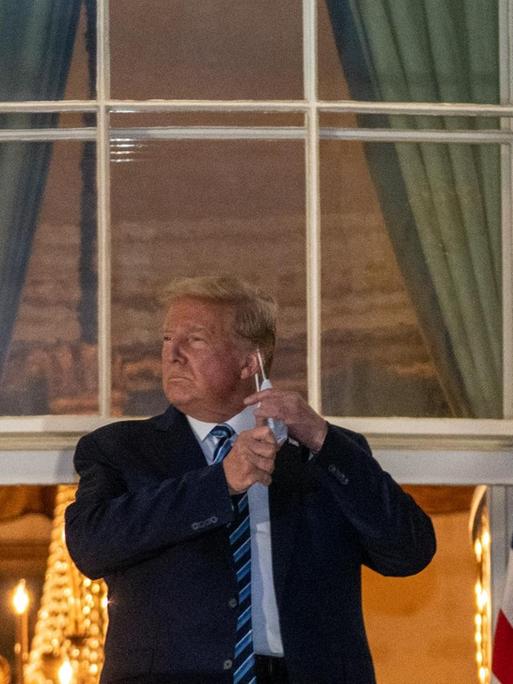 October 5, 2020 - Washington, DC, United States: President Donald J. Trump salutes from the Truman Balcony at the White House following several days at Walter Reed National Military Medical Center for treatment for COVID19. (Ken Cedeno / Polaris) Credit: Ken Cedeno / Pool via CNP | Verwendung weltweit