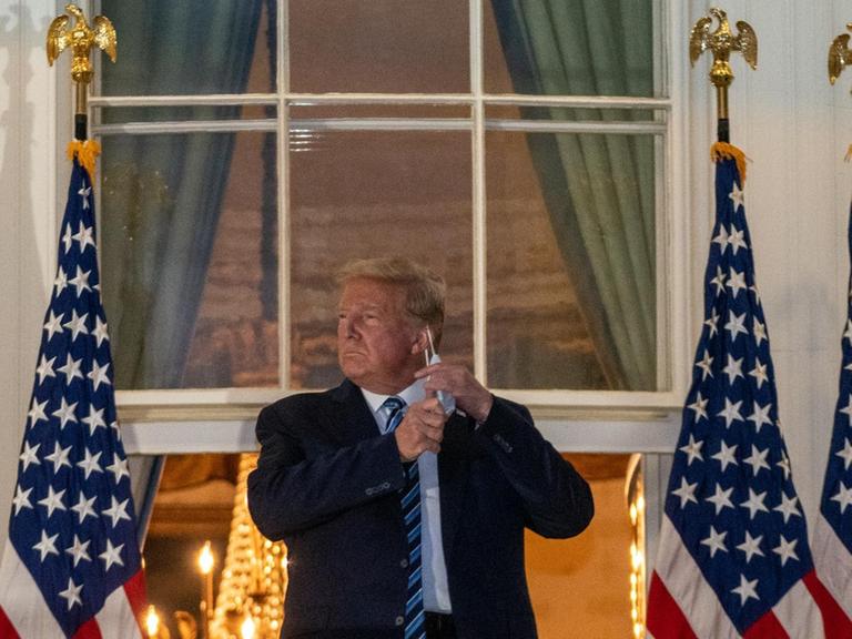 October 5, 2020 - Washington, DC, United States: President Donald J. Trump salutes from the Truman Balcony at the White House following several days at Walter Reed National Military Medical Center for treatment for COVID19. (Ken Cedeno / Polaris) Credit: Ken Cedeno / Pool via CNP | Verwendung weltweit
