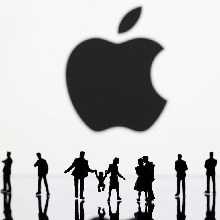Menschen unter einem sehr großen Apple-Logo Menschen unter einem sehr großen Apple-Logo